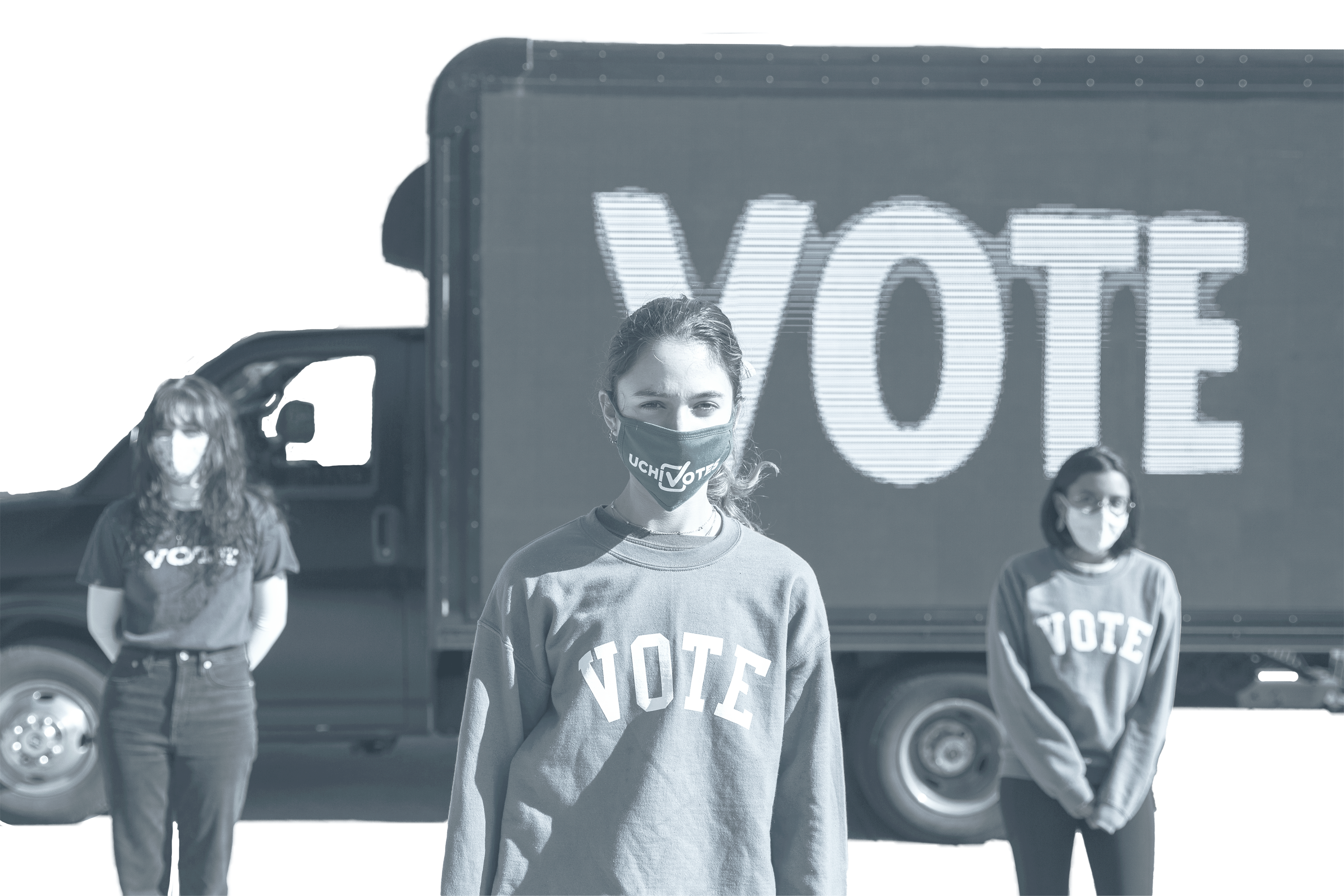 Students standing in front of truck with sign that reads "Vote"